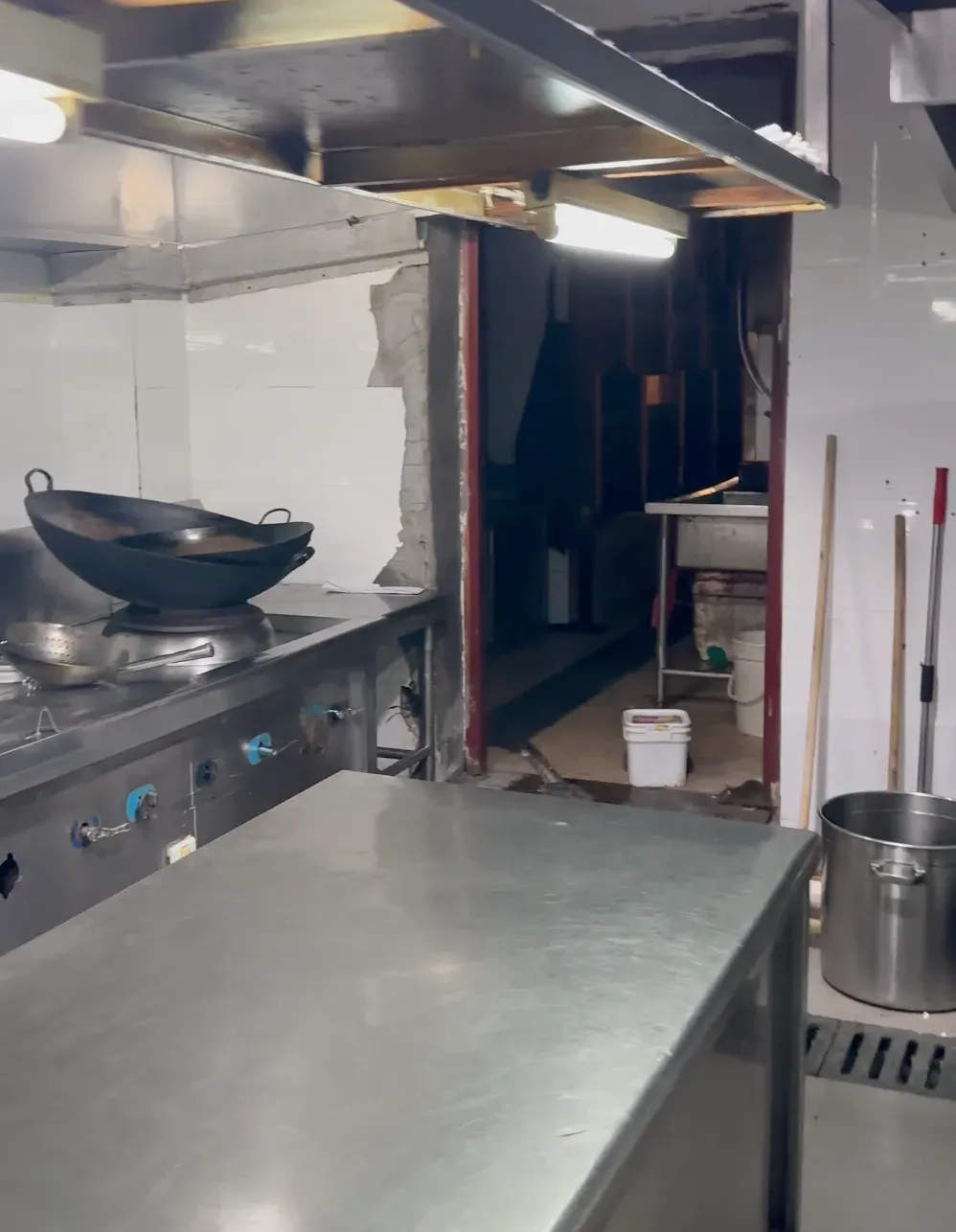 Commercial kitchen with gaps around the walls and floor drains where rodents get in